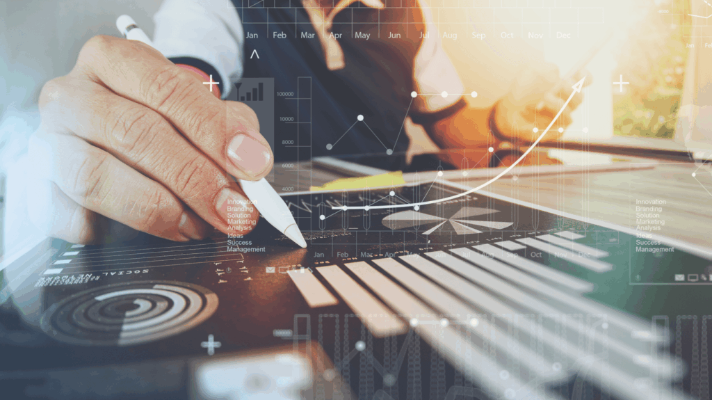 Hand holding a pen over a document with graphs and charts, overlaid with digital analytics and growth symbols.