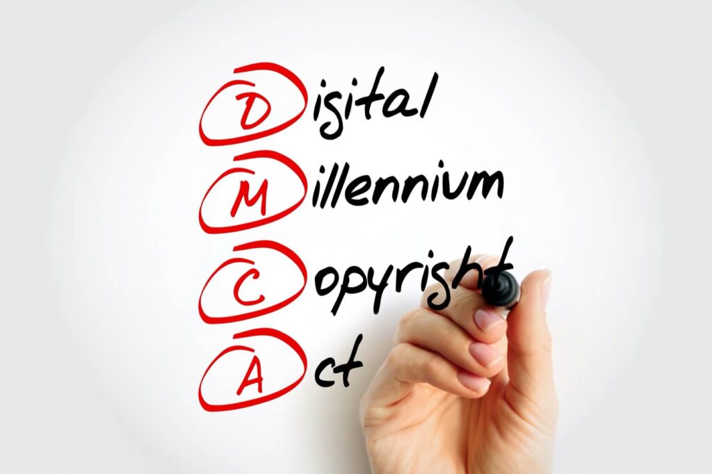Hand writing "Digital Millennium Copyright Act" with red circled initials "DMCA" on a whiteboard using a black marker.