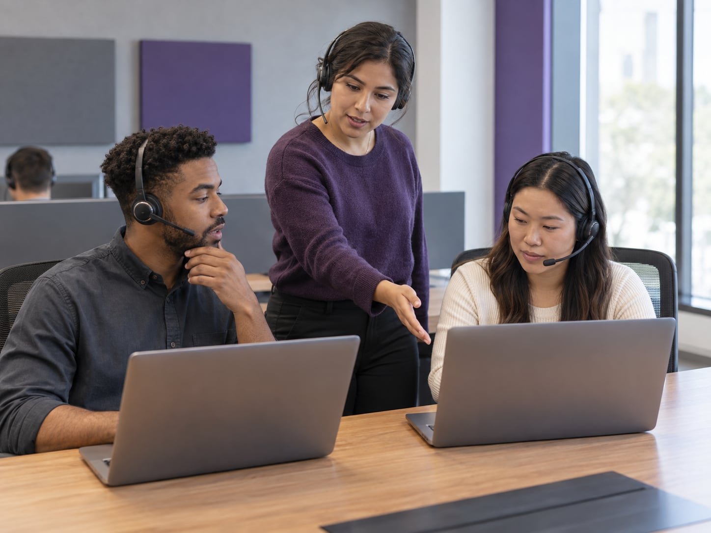 Customer support team coordinating live chat routing across shared workstations