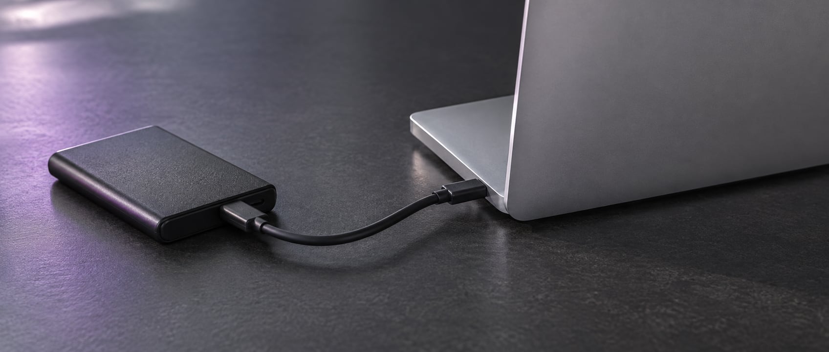 AI-generated conceptual photograph of a portable drive connected to a laptop, illustrating data transfer and preservation during a store migration.